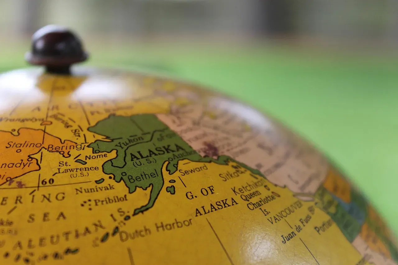 Gros plan sur un globe terrestre ancien, centré sur l'Alaska et la mer de Béring.